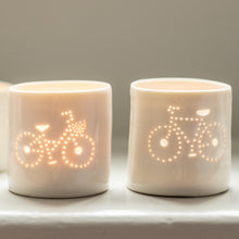 Load image into Gallery viewer, A pair of porcelain ceramic tealight candle holder votive, featuring a design of a bike with a basket and a crossbar. Natural glossy glaze. Bicycle. Cycling gift. Couples gift.