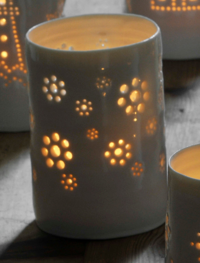 A natural porcelain ceramic tealight candle holder, with a floral design, resembling a field full of flowers, like a meadow. Homewares and decoration.