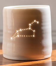 Load image into Gallery viewer, Handmade porcelain tealight holder. This ceramics candle holder has the astrological constellation of Leo pierced into it with tiny holes. Astrology, virgo birthdays, horoscopes, zodiac
