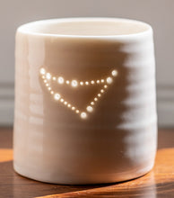 Load image into Gallery viewer, A ceramic porcelain tealight holder, with the Capricorn astrological constellation pierced into it with tiny holes, allowing candlelight to twinkle through. Natural glossy glaze, almost translucent. Horoscope, astrology, zodiac.
