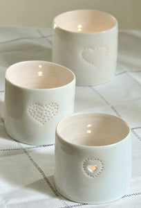 Trio of natural glazed porcelain ceramic tea light candle holders, with different heart designs, pierced with tiny holes. Anniversary wedding valentines gift. Cute lovely present.