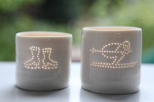 Ice skating, this ceramic porcelain tealight candle holder is a wintery treat. Homeware, Christmas and decoration. Next to a tealight holder featuring a skier design.
