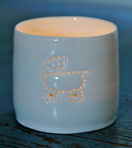 Porcelain ceramic tealight candle holder, glazed in a natural glossy glaze, and pierced with a baby pram design. New baby gift.