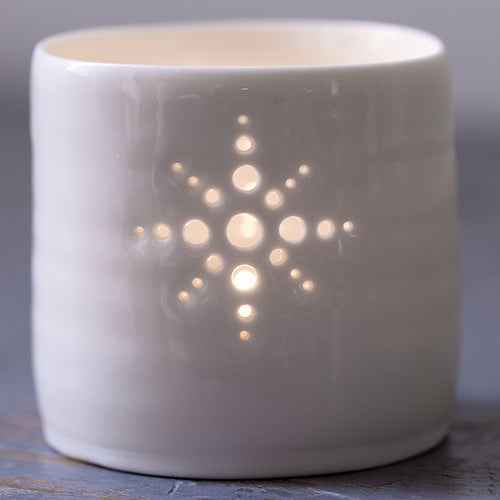 Porcelain ceramic tealight candle holder, glazed in a natural glossy glaze, and pierced with a snowflake design. Christmas gift. Decoration.