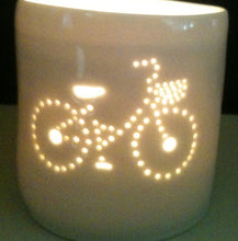 Load image into Gallery viewer, Porcelain ceramic tealight candle holder votive, featuring a design of a bike with a basket. Natural glossy glaze. Bicycle. Cycling gift. Illuminated.
