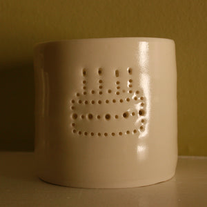 Porcelain ceramic tealight candle holder, featuring a design of a birthday cake with candles, natural glossy glaze. Unlit. Birthday present. Celebration.