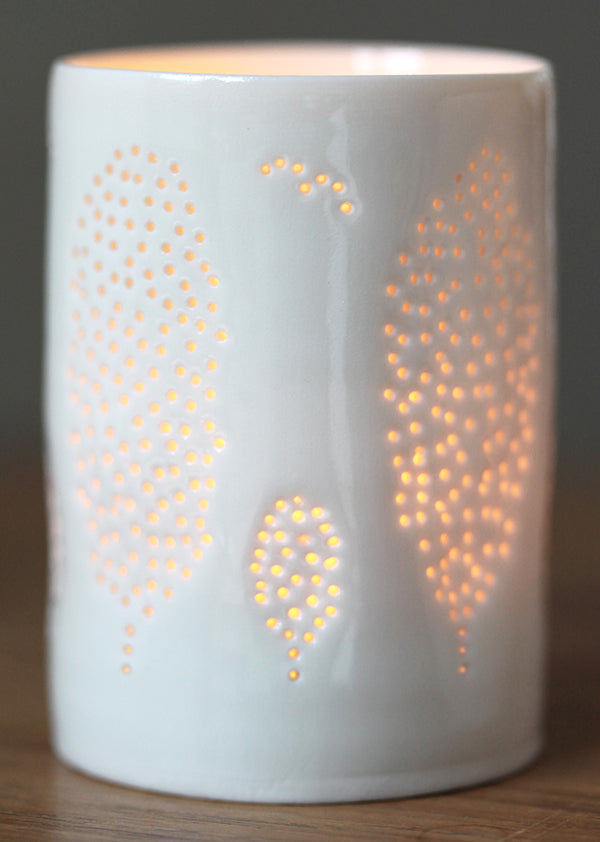 A porcelain ceramic tealight candle holder, this product has a design of Cypress trees all the way round. Mediterranean holidays and warm summer evenings.