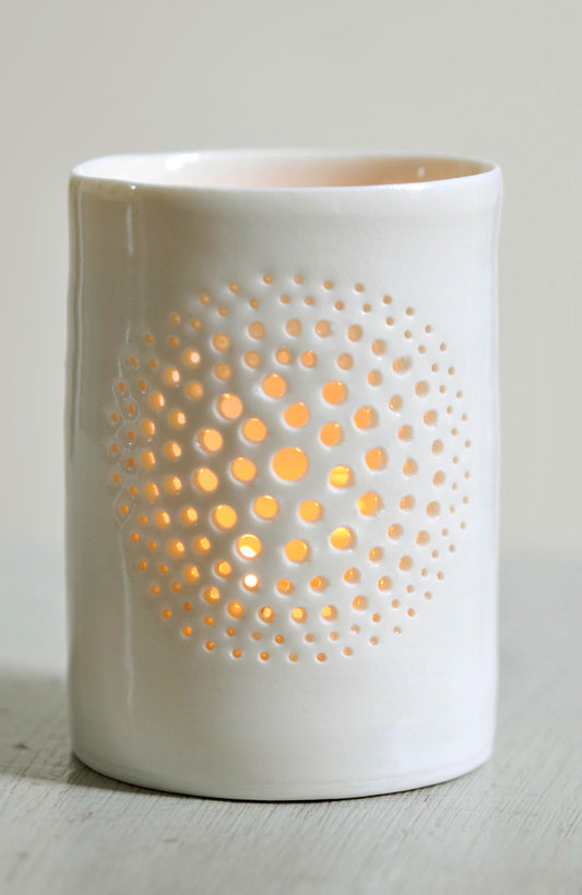 A natural porcelain ceramic tealight candle holder, with a floral design, resembling a large flower, like a dandelion. Homeware and garden decoration. Porcelain tableware.
