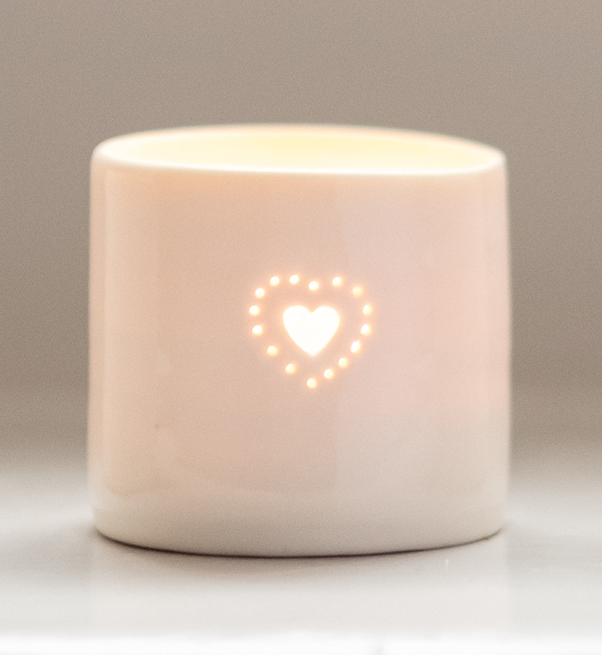 Natural glazed porcelain ceramic tea light candle holder, with a double heart design, pierced with tiny holes. Anniversary wedding valentines gift. Cute lovely present. Glowing in candlelight.