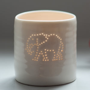 Tropical present. This porcelain ceramic tealight candle holder features a design of an elephant, pierced with tiny holes. Safari present.