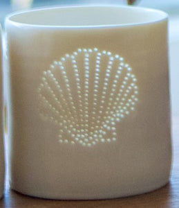 Ceramic tealight holder, this porcelain candle holder features a design of a shell. Natural glossy glaze, the light shines through the tiny holes to create a glow. Seaside.