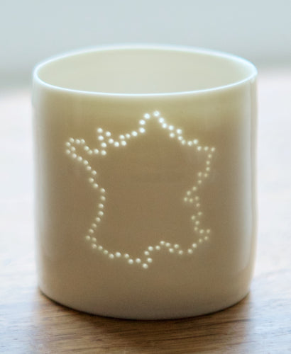 Francophiles delight - this ceramic tealight candle holder features the outline of France. Glazed with a natural gloss, the light shines from within. French present. Continental Europe.