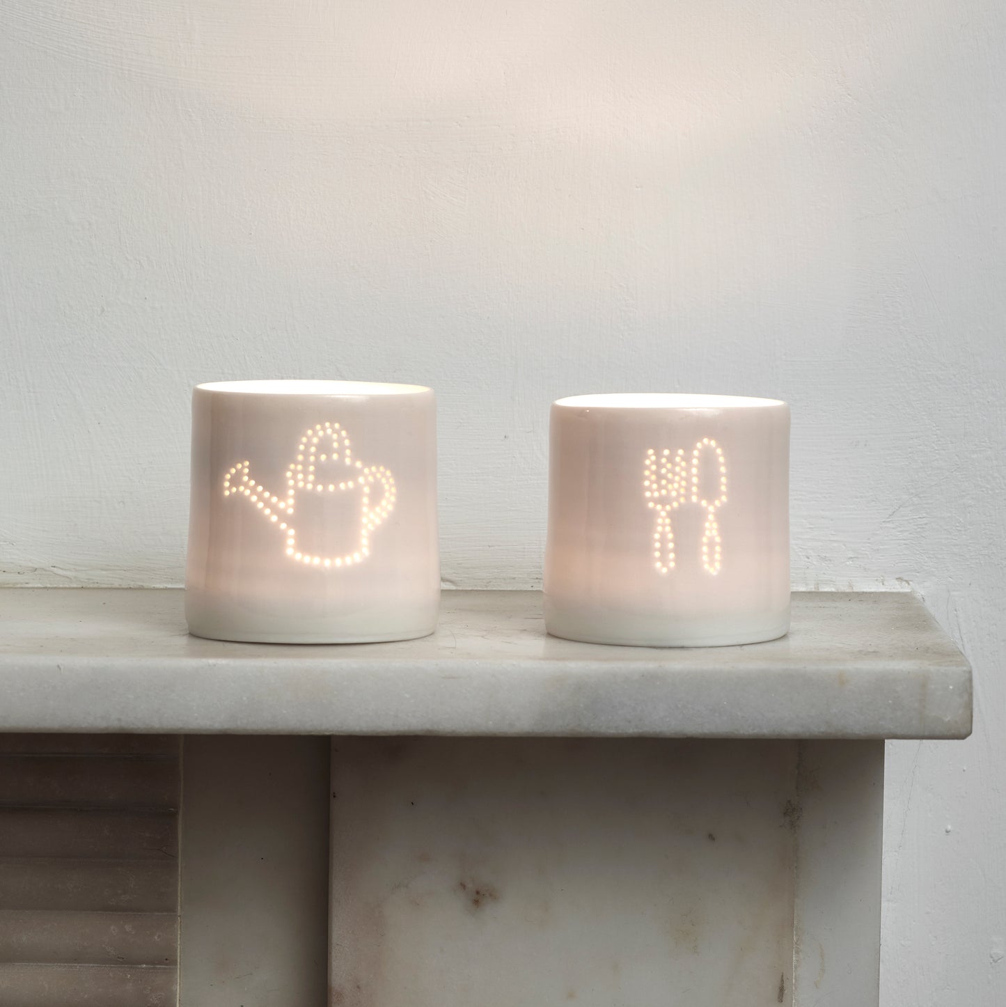 Green fingers present - this ceramic porcelain tealight candle holder features a fork and trowel design, and a watering can. Garden tools. Outdoor lighting. Table decoration. Glossy glaze creates a natural glow.