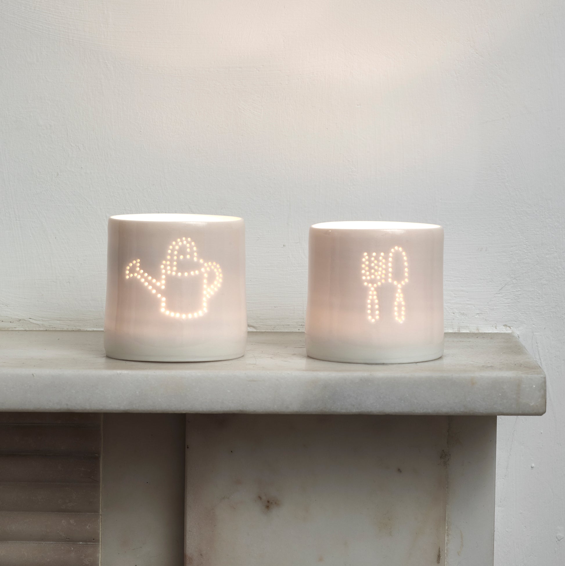 Green fingers present - this ceramic porcelain tealight candle holder features a fork and trowel design, and a watering can. Garden tools. Outdoor lighting. Table decoration. Glossy glaze creates a natural glow.