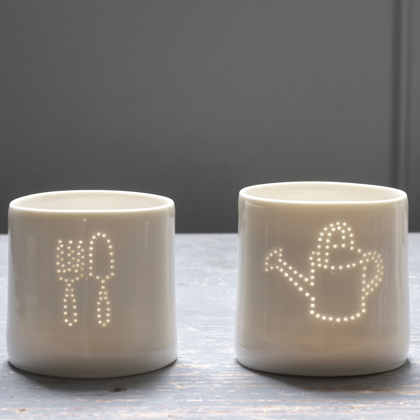 Green fingers present - this ceramic porcelain tealight candle holder features a fork and trowel design, and a watering can. Garden tools. Outdoor lighting. Table decoration. Glossy glaze creates a natural glow.
