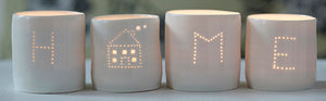 A perfect housewarming present, this set of four candle holders spells out HOME. These porcelain tealight holders create a flickering sense of calm and relaxation.