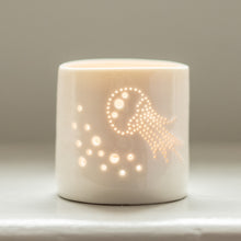 Load image into Gallery viewer, Porcelain candle holder with delicate jellyfish design pierced into it. Candlelight flickers through the holes. Ceramic tealight holder for seaside holidays.
