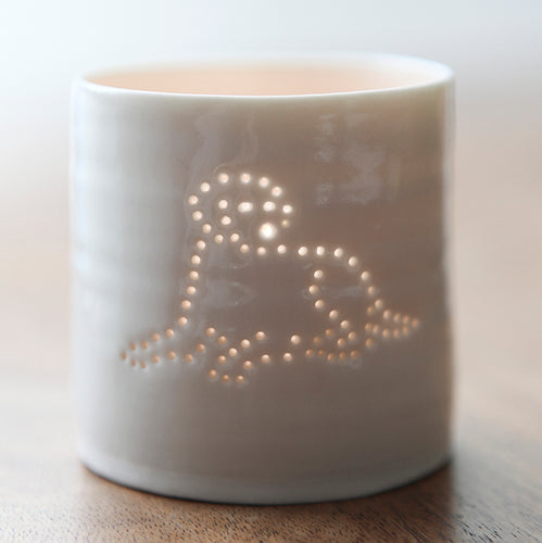 A ceramic tealight holder with a design of a Labrador lying down. This porcelain candle holder is simple and scandi chic.