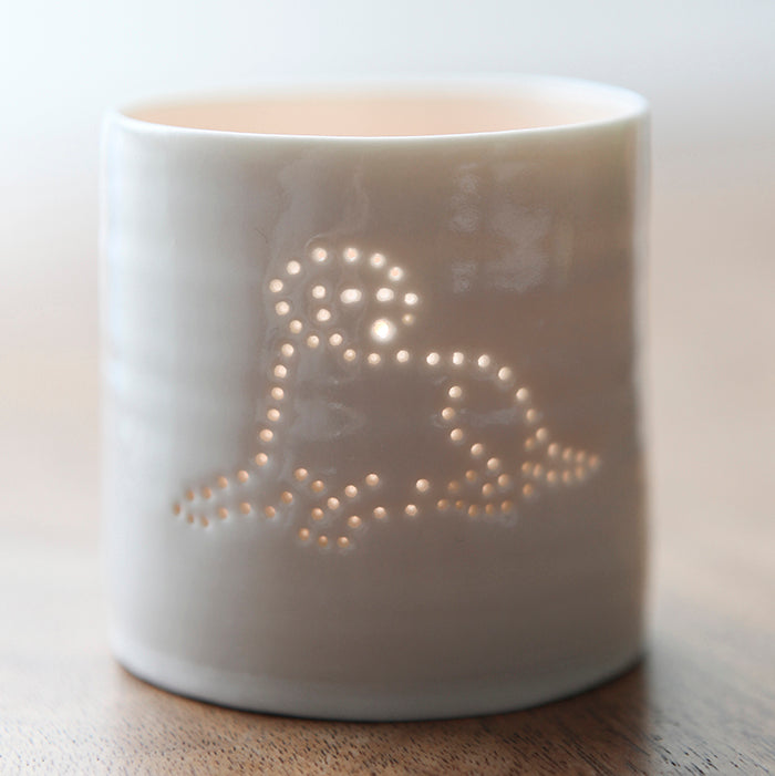 A ceramic tealight holder with a design of a Labrador lying down. This porcelain candle holder is simple and scandi chic.