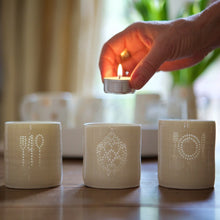 Load image into Gallery viewer, Three foodie themed porcelain ceramic tealight candle holders, with the light shining through their translucence. Knife, fork and spoon. Artichoke. And a plate.
