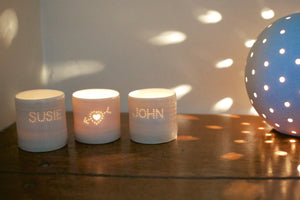 Three cute ceramic porcelain tealight holders. Two of them are personalised with a couple's names, and the third has a cupids heart pierced into it. There are small holes, that let candlelight shine through. Natural glossy glaze, almost translucent. Romantic gift.