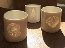 Load image into Gallery viewer, Three ceramic porcelain tealight candle holders, featuring different shell designs. Homeware for relaxing and creating a calm atmosphere. Celebrate a seaside holiday.
